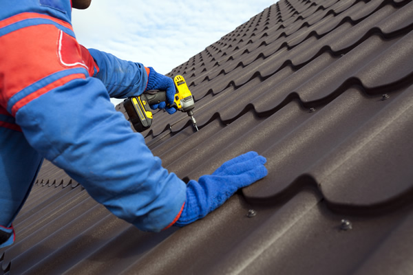 Worker drilling metal sheets